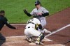Colorado Rockies' Jake McCarthy, rear, is tagged out by Pittsburgh Pirates catcher Henry Davis attempting to score on a fielder's choice by Brett Sullivan during the fifth inning of a baseball game in Pittsburgh, Wednesday, May 13, 2026. (AP Photo/Gene J. Puskar)