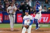 Los Angeles Dodgers two-way player Shohei Ohtani, center, reacts after striking out San Francisco Giants' Rafael Devers, left, as catcher Will Smith gets ready to throw the ball back during the sixth inning of a baseball game Wednesday, May 13, 2026, in Los Angeles. (AP Photo/Mark J. Terrill)