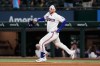 Texas Rangers' Danny Jansen celebrates his run-scoring single as he rounds first in the ninth inning of a baseball game against the Arizona Diamondbacks Wednesday, May 13, 2026, in Arlington, Texas. (AP Photo/Tony Gutierrez)