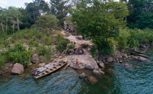FILE - A fisher sits outside his home on the banks of the Xingu River, near the Belo Monte hydroelectric dam in Altamira, Para state, Brazil, Sept. 6, 2019. (AP Photo/Andre Penner, File)