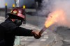 A miner launches a firecracker at police during an anti-government protest in La Paz, Bolivia, Monday, May 18, 2026. (AP Photo/Juan Karita)