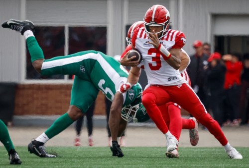 Saskatchewan Roughriders' Justin Weaver, left, dives for Calgary Stampeders quarterback Vernon Adams Jr. during first half preseason CFL football action in Calgary, Monday, May 18, 2026.THE CANADIAN PRESS/Jeff McIntosh