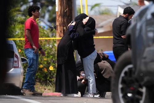 People embrace near the scene of a shooting outside the Islamic Center of San Diego Monday, May 18, 2026, in San Diego. (AP Photo/Gregory Bull)