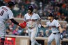 Cleveland Guardians' Brayan Rocchio, center, and Steven Kwan, right, celebrate with Rhys Hoskins (8) after scoring against the Detroit Tigers on a double by Jose Ramirez during the sixth inning of a baseball game, Monday, May 18, 2026, in Detroit. (AP Photo/Duane Burleson)