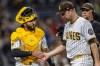 San Diego Padres catcher Rodolfo Durán, left, gives a hand to starting pitcher Michael King, front right, after the in the sixth inning of a baseball game against the Los Angeles Dodgers, Monday, May 18, 2026, in San Diego. (AP Photo/Tony Ding)