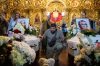 A man kneels next to the coffins of sisters Liubava and Vira Yakovleva, killed by a Russian rocket strike on a residential building earlier this month, during their funeral, in Kyiv, Ukraine, Tuesday, May 19, 2026. (AP Photo/Evgeniy Maloletka)