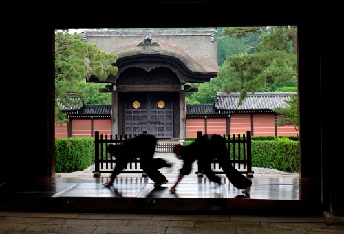 FILE - Monks polish the wooden corridor of the walkway that connects between temple buildings at Soji-ji in Yokohama, Japan on July 5, 2016. (AP Photo/Kiichiro Sato, File)