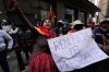An anti-government protester holds a sign that reads in Spanish 