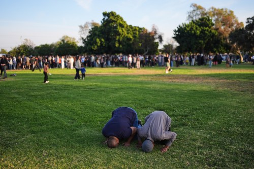 Two people pray during a vigil, the day after a shooting, outside of the Islamic Center of San Diego, Tuesday, May 19, 2026, in San Diego. (AP Photo/Jae C. Hong)