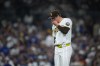 San Diego Padres pitcher Mason Miller reacts after giving up a sacrifice fly during the ninth inning of a baseball game against the Los Angeles Dodgers Tuesday, May 19, 2026, in San Diego. (AP Photo/Gregory Bull)