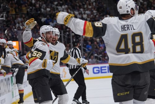 Vegas Golden Knights defenseman Dylan Coghlan, front left, is congratulated after scoring a goal by defenseman Shea Theodore, back left, and center Tomas Hertl during the second period in Game 1 of the Western Conference finals NHL hockey Stanley Cup playoff series against the Colorado Avalanche Wednesday, May 20, 2026, in Denver. (AP Photo/David Zalubowski)