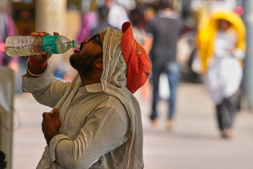 A commuter drinks water on a hot afternoon in New Delhi, India, Wednesday, May 20, 2026. (AP Photo/Manish Swarup)