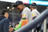 Atlanta Braves' Ronald Acuna, right, has his finger looked at during the fifth inning of a baseball game against the Miami Marlins, Thursday, May 21, 2026, in Miami. (AP Photo/Lynne Sladky)