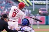 Los Angeles Angels' Zach Neto, center, hits a solo home run as Texas Rangers catcher Danny Jansen, right, and home plate umpire Sean Barber watch during the first inning of a baseball game Friday, May 22, 2026, in Anaheim, Calif. (AP Photo/Mark J. Terrill)
