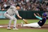 Colorado Rockies third baseman Chad Stevens, left, reaches out to catch a late throw as Arizona Diamondbacks' Nolan Arenado advances to third base during the second inning of a baseball game, Friday, May 22, 2026, in Phoenix. (AP Photo/Ross D. Franklin)