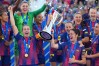 Barcelona's Alexia Putellas, left, and Marta Torrejon celebrate with the trophy after winning the Women's Champions League final soccer match between FC Barcelona and OL Lyonnes, in Oslo, Saturday, May 23, 2026. (AP Photo/Kirsty Wigglesworth)