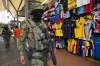 Soldiers patrol past shops selling soccer jerseys at a market in Guayaquil, Ecuador, Friday, May 15, 2026. (AP Photo/Dolores Ochoa)