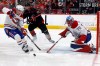 Montreal Canadiens' Lane Hutson, left, clears the puck from the goal area with Canadiens goaltender Jakub Dobes (75) and Carolina Hurricanes' Andrei Svechnikov (37) nearby during the second period in Game 2 of the Eastern Conference final NHL hockey Stanley Cup playoff series in Raleigh, N.C., Saturday, May 23, 2026. (AP Photo/Karl DeBlaker)