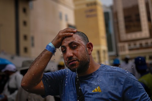 A Muslim pilgrim splashes water over his head too cool down outside the Grand Mosque during the annual hajj pilgrimage at the holy city of Mecca, Saudi Arabia, Sunday, May 24, 2026. (AP Photo/Altaf Qadri)