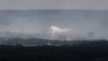 A water bomber provides a steady steam of water to assist crews on the ground at the Paddy's Pond wildfire, just outside St. John's, N.L., on Thursday, Aug. 14, 2025. THE CANADIAN PRESS/Paul Daly