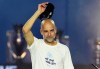 Manchester City manager Pep Guardiola raises his hat to the crowd during a stage event following a parade to celebrate the achievements of the Manchester City men's and women's teams this season in Manchester, England, Monday, May 25, 2026. (Nick Potts/PA via AP)