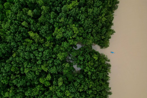 FILE - A fishing boat sails at the mouth of the Uaca River, in the Uaca Indigenous Territory region, near the mangrove and biodiversity conservation area of Cabo Orange, in Oiapoque, Amapa state, Brazil, March 12, 2026. (AP Photo/Eraldo Peres, File)