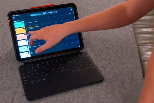 LuAnn Oliver's son demonstrates how he uses an iPad for his classes during a meeting where a group of school parents discussed ways to push back against screen time at the children's school, Saturday, May 9, 2026 in Arlington, Va. (AP Photo/Kevin Wolf)