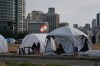 Displaced people who fled Israeli strikes in southern Lebanon sit outside shelter tents in Beirut, April 24, 2026. (AP Photo/Bilal Hussein)