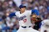 Los Angeles Dodgers two-way player Shohei Ohtani, right, throws to the plate during the first inning of a baseball game against the Colorado Rockies, Wednesday, May 27, 2026, in Los Angeles. (AP Photo/Mark J. Terrill)
