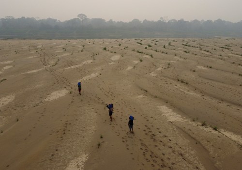 FILE - Residents transport drinking water from Humaita to the Paraizinho community, along the dry Madeira River, a tributary of the Amazon River, during the dry season, Amazonas state, Brazil, Sept. 8, 2024. (AP Photo/Edmar Barros, File)
