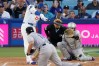 Los Angeles Dodgers' Shohei Ohtani, left, hits a solo home run as Colorado Rockies pitcher Tomoyuki Sugano, center, and catcher Hunter Goodman watch during the first inning of a baseball game Wednesday, May 27, 2026, in Los Angeles. (AP Photo/Mark J. Terrill)