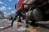 A man fills water jugs from a tanker truck in Havana, Thursday, May 28, 2026. (AP Photo/Ramon Espinosa)