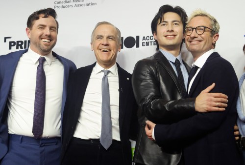 Prime Minister Mark Carney poses for a photo on the red carpet with, left to right, Brendan Brady, co-creator of the TV series 