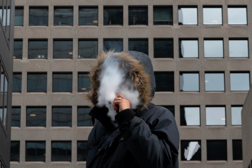 A person exhales a cloud of vapour in a photo illustration made in the Financial District of Toronto, Wednesday, Feb. 5, 2025. THE CANADIAN PRESS/Giordano Ciampini