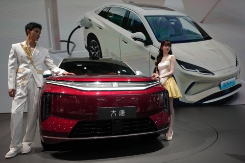 Models stand next to a latest EV car from Chinese automaker BYD showcased at the Auto China 2026, in Beijing, Saturday, April 25, 2026. (AP Photo/Andy Wong)