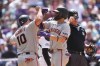 San Francisco Giants' Casey Schmitt, left, congratulates Willy Adames, front right, crosses home plate after hitting a grand slam off Colorado Rockies relief pitcher Zach Agnos in the fifth inning of a baseball game Sunday, May 31, 2026, in Denver. (AP Photo/David Zalubowski)