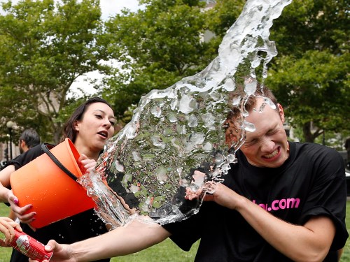 Beryl Lipton, left, douses Matt Lee during the ice bucket challenge at Boston's Copley Square, Thursday, Aug. 7, 2014 to raise funds and awareness for ALS. (AP Photo/Elise Amendola)