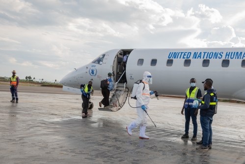 A health worker disinfects the airport near the World Food Programme's (WFP) aircraft following the government's announcement of Bunia National Airport's reopening in Bunia, Congo, Tuesday, June 2, 2026. (AP Photo/Moses Sawasawa)