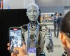 People take photos of an AI robot at the All In artificial intelligence conference Wednesday, September 27, 2023 in Montreal. THE CANADIAN PRESS/Ryan Remiorz