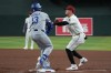 Los Angeles Dodgers' Max Muncy (13) and Arizona Diamondbacks first baseman Ildemaro Vargas, right, collide on a play in the fifth inning of a baseball game, Thursday, June 4, 2026, in Phoenix. (AP Photo/Rick Scuteri)