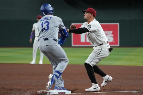 Los Angeles Dodgers' Max Muncy (13) and Arizona Diamondbacks first baseman Ildemaro Vargas, right, collide on a play in the fifth inning of a baseball game, Thursday, June 4, 2026, in Phoenix. (AP Photo/Rick Scuteri)