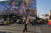 People walk under a banner showing portraits of the late revolutionary founder Ayatollah Khomeini, left, and the slain Supreme Leader Ayatollah Ali Khamenei, who was killed in U.S. and Israeli strikes on Feb. 28, in Tehran, Iran, Saturday, June 6, 2026. (AP Photo/Vahid Salemi)