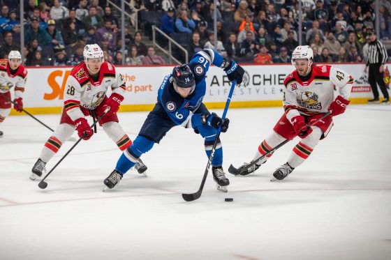 Manitoba Moose left-winger Samuel Fagemo (No. 16) plays the puck while Grand Rapids Griffins right-winger Michael Brandsegg-Nygård (No. 28) and Griffins teammate right-winger Carter Mazur (No. 43) cover him during Saturday's game. Also pictured is Griffins centre Amadeus Lombardi (No. 93). (Brook Jones / Free Press)