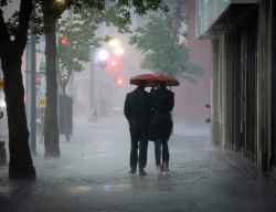 People run for cover during stormy conditions on Portage Avenue in Winnipeg on Tuesday. (John Woods / Free Press)