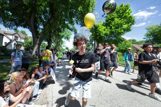 St. John’s High School graduating student Talon Phrakonekhan takes part in Grad Walk  Tuesday afternoon, along with students from Children of the Earth, RB Russell, and Villa Rosa. The grads walked from St. John’s to RB Russell while kids from nearby schools lined the streets to cheer them on along the way.  (Ruth Bonneville / Free Press)