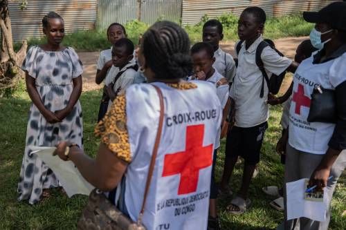 Moses Sawasawa / The Associated Press
                                Vanny Birungi, a Red Cross volunteer, speaks to people during a house-to-house sensitization campaign amid the Ebola outbreak in Bunia, Congo in May.