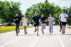 MIKAELA MACKENZIE / FREE PRESS
                                Coun. Brian Mayes runs with St. James Collegiate students and staff on the existing track after announcing funding to upgrade it on Thursday.