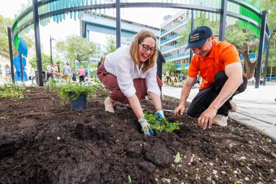 Kate Fenske, CEO of Downtown Winnipeg BIZ, and Maverick Dysart plant a Uva Ursi or Bearberry plant in the garden after the grand re-opening of Air Canada Window Park. (Mike Deal / Free Press)