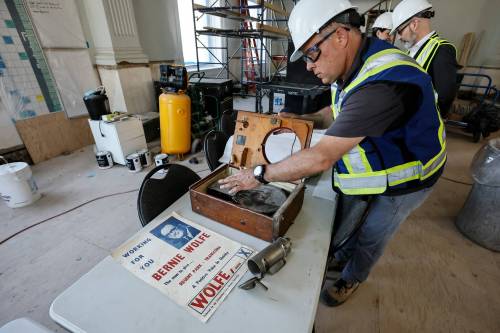 JOHN WOODS / FREE PRESSJim Manning, project manager with Bockstael, looks at some found items as he and Konrad Krahn, city archivist, give a tour and update media on the renovations of the future home of the City of Winnipeg Archives building.