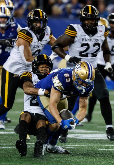 JOHN WOODS / THE CANADIAN PRESS
                                Winnipeg Blue Bombers receiver Tommy Nield fights for yards against the Hamilton Tiger-Cats defence. The receiver had his first career 100-yard game on Thursday night.